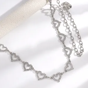 Détail macro d'une ceinture chaîne argentée en forme de cœur avec strass brillants