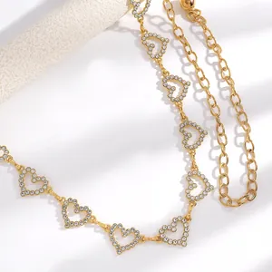 Vue détaillée d'une chaîne de taille dorée en forme de cœur avec strass brillants.