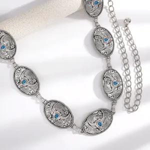 Gros plan détaillé d'une ceinture chaîne de taille bohème vintage en métal avec pierres bleues