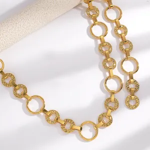 Détail macro d'une ceinture chaîne dorée avec maillons circulaires martelés et lisses