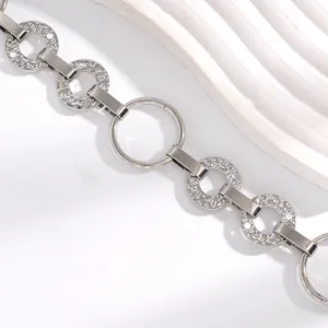 Détail d'une chaîne de taille en métal argenté avec maillons texturés pour femme