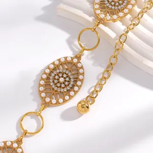 Détail élégant d'une chaîne de taille vintage dorée avec perles blanches et strass brillants
