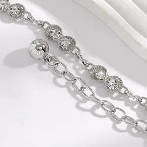 Détail rapproché d'une chaîne de taille argentée en forme de coquillage strass