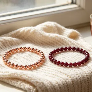 Close-up detail of 6mm natural garnet and rose gold copper beaded bracelets on knitwear.