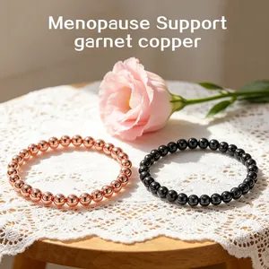 Close-up detail of 6mm natural black garnet and rose gold copper bead bracelets on white lace