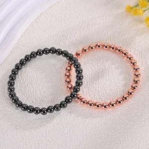 Macro view of 6mm black garnet and rose gold copper bead elastic bracelets