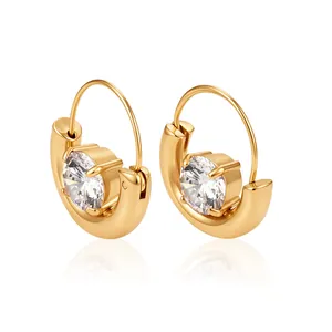 Nahaufnahme eleganter goldener Edelstahl-Ohrringe in Korbform mit funkelnden Kristallen