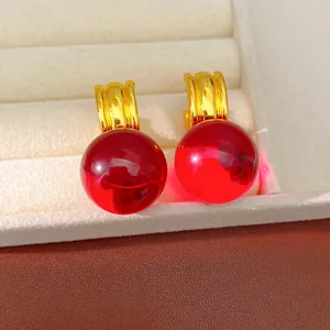 Gros plan de sphères en résine rouge vibrant avec des anneaux dorés minimalistes modernes
