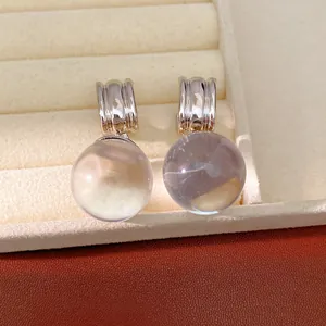 Détail macro de boucles d'oreilles rondes en résine translucide colorée avec créoles.