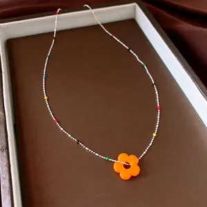 Elegante kleurrijke kralenketting met een levendige oranje bloemenhanger voor dames