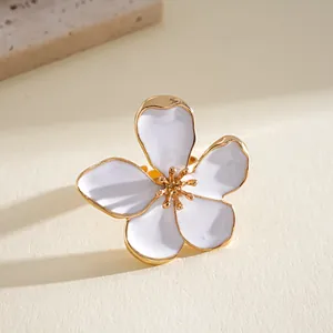Detailed macro shot of a white enamel flower ring with gold metal edges and stamen
