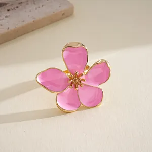 Detailed close-up of a pink enamel flower ring with elegant gold-tone metal petals for women