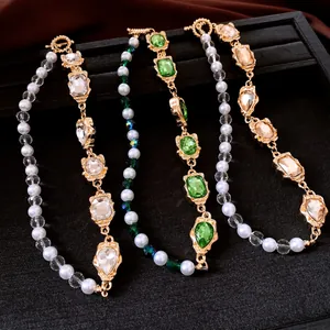 Detail view of four French vintage pearl and gemstone necklaces on a black tray