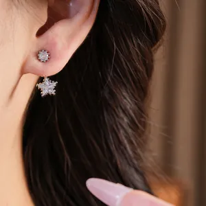 Detailaufnahme von minimalistischen Silber-Stern-Ohrringen mit Zirkonia am Ohr getragen