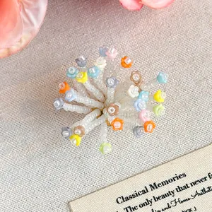 Dettaglio di ciondoli a fiore di perline colorate per decorare scarpe zoccoli