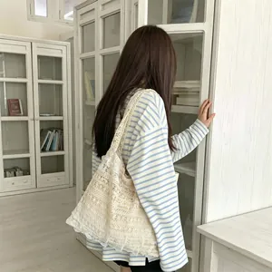 Detailed macro view showing the delicate hollow-out lace patterns on a cream canvas tote bag