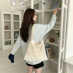 Asian model carrying a large hollow out lace canvas tote bag in a bright setting