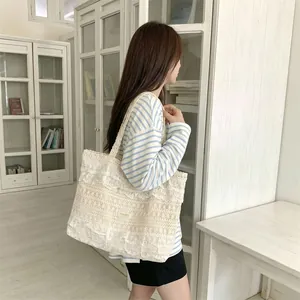 Large white lace canvas tote bag with ruffles and hollow-out design shown on model