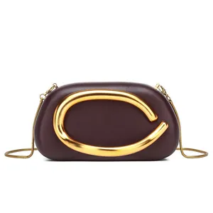 Elegante borsa a tracolla in pelle bordeaux con un grande manico decorativo a C dorato