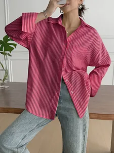 Stylish pink and white vertical striped long-sleeved button-down shirt styled with denim