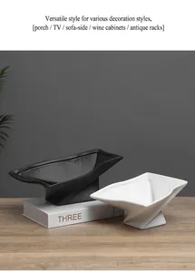 Close-up detail of modern Wabi-sabi black and white ceramic footed trays on wood surface