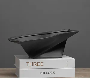 Modern matte black geometric decorative tray displayed on white art books