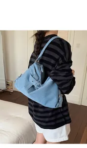 Vue latérale détaillée d'un sac à bandoulière en denim bleu vintage avec boucle rétro
