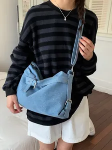 Sac hobo en denim bleu clair vintage porté par un mannequin dans un cadre intérieur