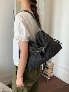 Grand sac cabas vintage en denim délavé de style motard porté par un mannequin