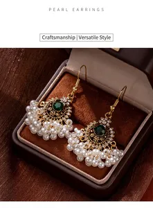 Close-up of ethnic Bohemian pearl tassel hook earrings in a luxury jewelry box.