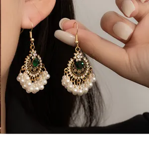 Detail shot of ethnic style pearl tassel earrings with green gemstones