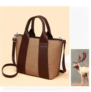 Modische Damenhandtasche mit großer Kapazität, Webstruktur und braunen Riemen im Detail.
