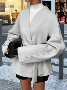 Détail d'un blazer élégant gris clair à manches longues avec ceinture pour l'hiver.