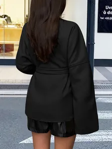 Blazer noir élégant avec ceinture pour femme dans un décor de rue urbain chic