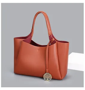 Détail du grand sac cabas en cuir orange avec son pendentif arbre de vie doré
