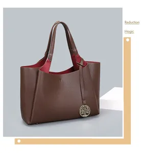 Grand sac cabas marron en cuir grainé avec doublure rouge et élégant détail charm