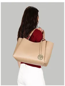 Détail d'un grand sac fourre-tout beige avec breloque arbre de vie dorée