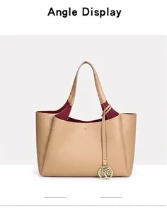 Vue de face d'un grand sac cabas beige avec doublure bordeaux et charm doré