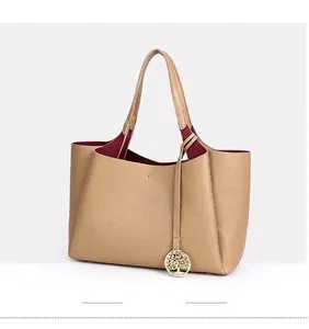 Vue détaillée du sac cabas en cuir beige avec breloque arbre de vie dorée