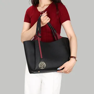 Grand sac cabas en cuir grainé noir avec breloque arbre dorée porté par mannequin