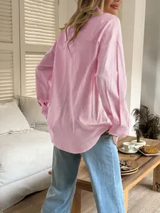 Back view of a casual pink long-sleeved shirt for women in a cozy indoor setting