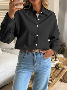 Detail of a casual black long-sleeved shirt styled with light blue jeans and belt