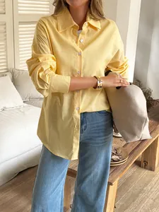 Detail view of a relaxed-fit pale yellow linen shirt with long sleeves and classic collar