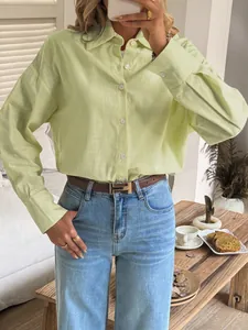 Close-up detail of a lime green button-down shirt styled with a belt and blue jeans