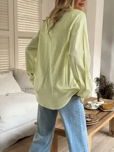 Rear view of a casual light lime green long-sleeved button-down shirt for women