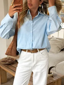 High-quality close-up of a light blue long-sleeved casual shirt for women in a lifestyle setting