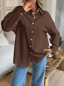 Detail shot of a brown long-sleeved loose fit blouse for casual vacation style