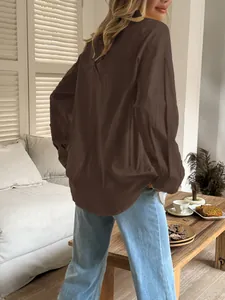 Back view of a relaxed fit brown long-sleeved shirt for women in a home setting