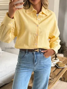 Stylish yellow long sleeve button-down shirt for women styled with jeans and a belt