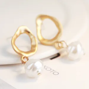 Detailed view of baroque pearl drop earrings with elegant gold irregular hoops design